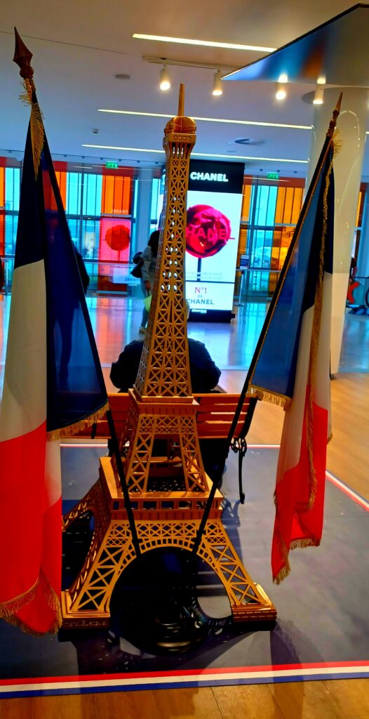Eiffel Tower (La Tour Eiffel) and French flag display at CDG (Charles De Gaulle) International Airport